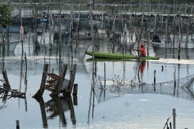 Nelayan Memberi Pakan Ikan Di Waduk Lhokseumawe